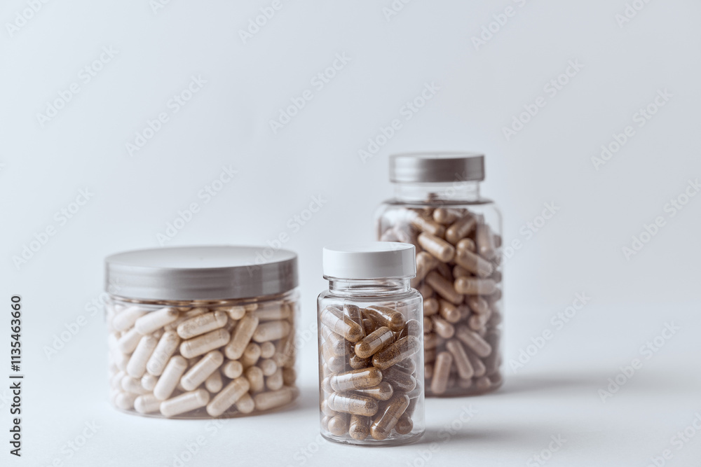 Clear supplement capsules filled with beige and brown powders in clear pet jar pharmaceutical concept Clear supplement capsules filled with beige and brown powders in clear pet jar pharmaceutical concept