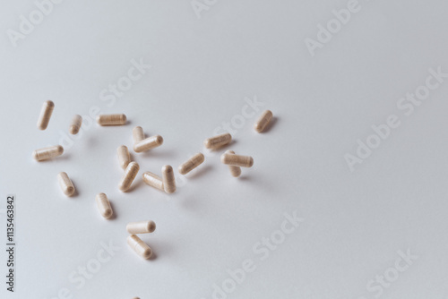 Clear capsules filled with beige powder spilled on white background pharmaceutical concept