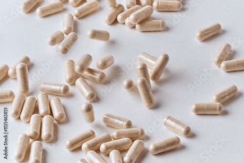 Clear capsules filled with beige powder spilled on white background pharmaceutical concept