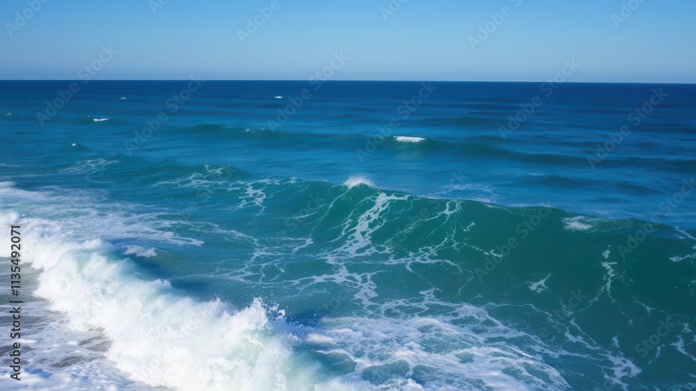 Fototapeta premium Powerful ocean wave crashing on the shore under a clear blue sky, shore, clear sky