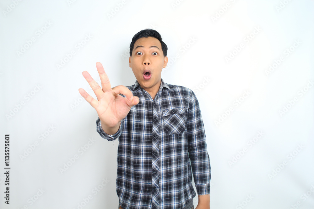 funny asian man showing okay symbol using hand with surprised and shocked expression isolated on white funny asian man showing okay symbol using hand with surprised and shocked expression isolated on white