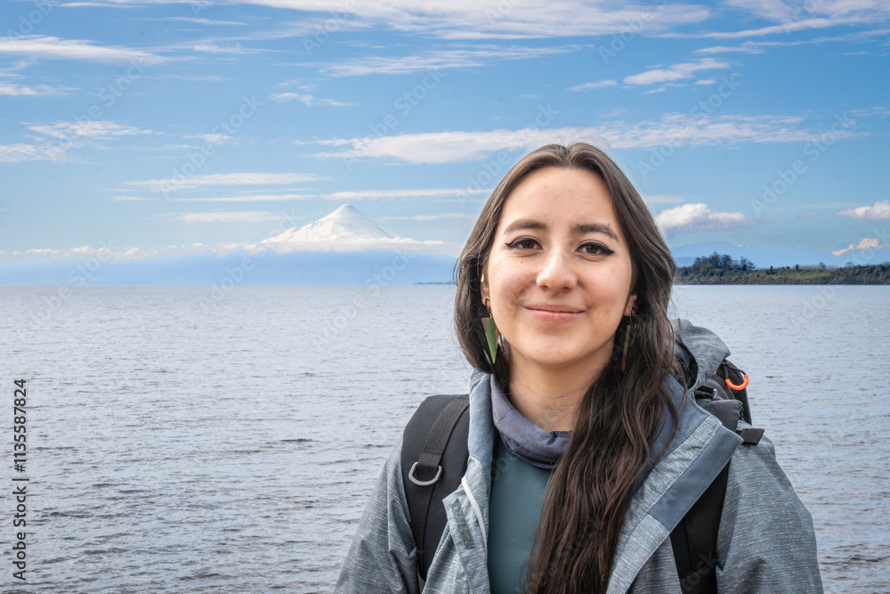 Puerto Varas, Los Lagos, Chile. Young woman traveler - tourist next to the snow-capped volcano Osorno and Lake Llanquihue as seen from the city of Puerto Varas in Chilean Patagonia. Puerto Varas, Los Lagos, Chile. Young woman traveler - tourist next to the snow-capped volcano Osorno and Lake Llanquihue as seen from the city of Puerto Varas in Chilean Patagonia.