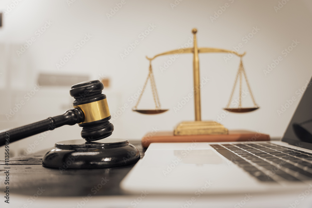 A lawyer's desk featuring a judge's hammer, an open notebook, and the Scales of Justice, symbolizing law, legal services, and criminal justice. No people are present A lawyer's desk featuring a judge's hammer, an open notebook, and the Scales of Justice, symbolizing law, legal services, and criminal justice. No people are present