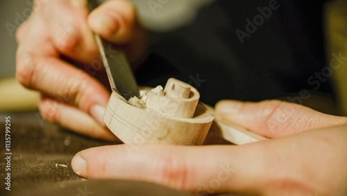 Fotografie Luthier carefully carving violin scroll with chisel