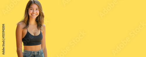 Smiling young woman standing against a vibrant yellow background, providing a cheerful and engaging atmosphere, copy space for personalized designs or text, perfect for marketing or creative projects.