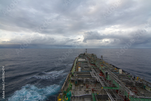 A merchant ship underway at sea under overcast sky