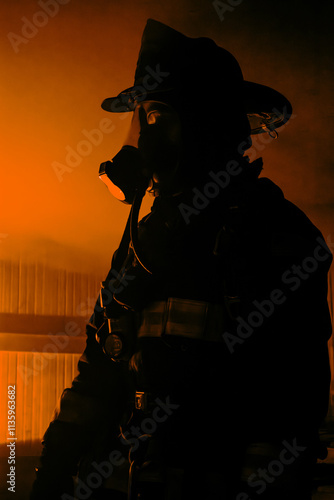 Silhouette of a Firefighter in a room with fire as part of a training house burn.