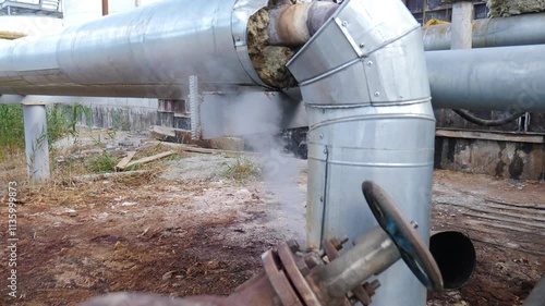 Heavy industry concept. Industrial factory or factory emitting steam from pipes on a working day. Heating equipment in a boiler room of the large enterprise. Steam leaking. 4 k video