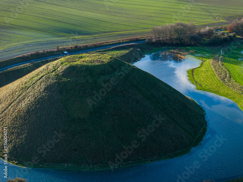 Telephoto aerial shot of Silbury Hill and surrounding lake on a sunny winter day, Wiltshire, UK photo