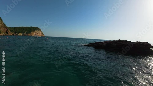 Aerial DJI fpv racing drone flying over sea waters along Galija coast in Budva region of Montenegro