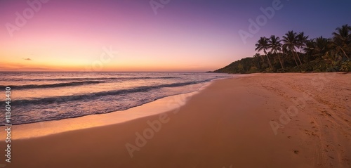 A tranquil beach at twilight, the sky ablaze with color, the waves gently lapping at the shore