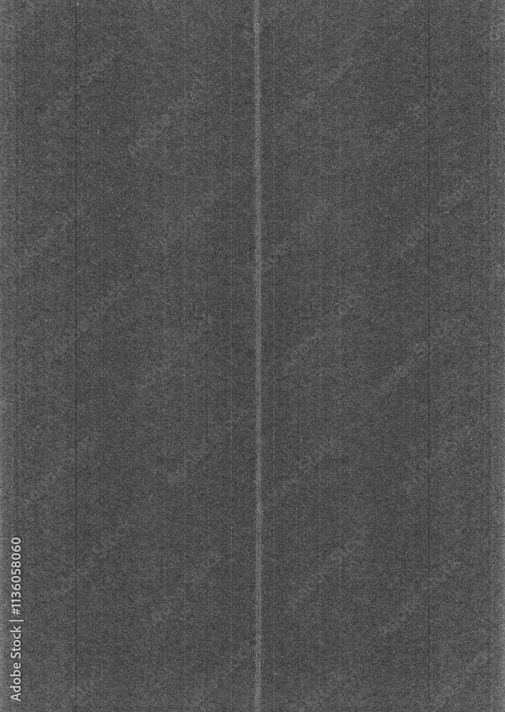 Fototapeta premium Black and white, gray paper texture background with vertical lines. The paper is folded into two parts. Top view of a textured, dark gray cardboard surface.