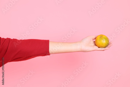 hand holding Tangerine or Orange