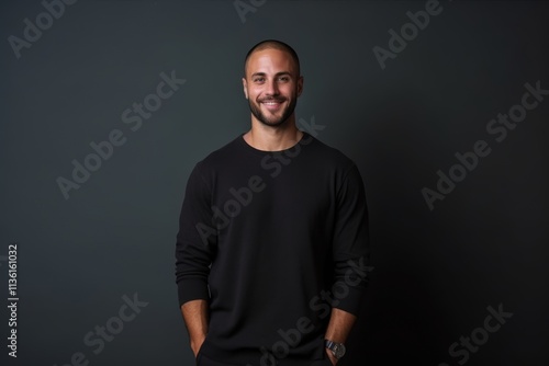 A man in a black shirt is smiling and looking at the camera