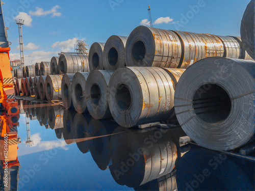 Stacks of steel sheet rolls in the port, cold rolled steel rolls. A roll of sheet iron. Hot rolled steel rolls are stored outdoors. Rolls of steel sheet. Sheet metal in the port. 