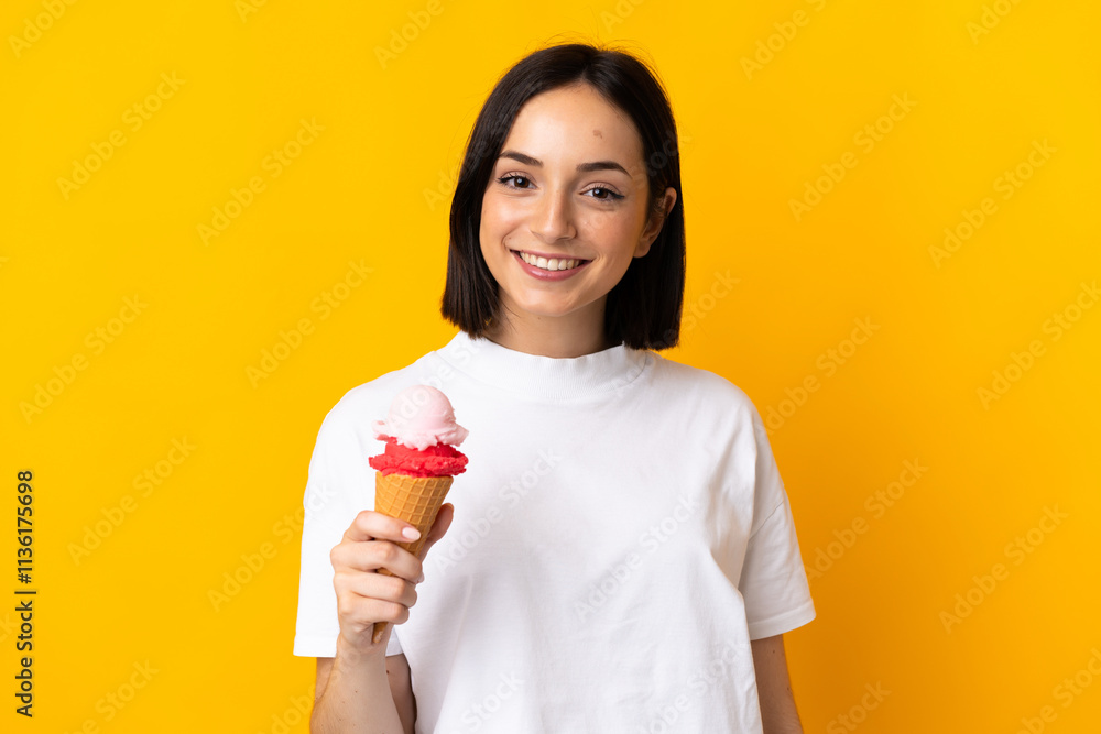 Young caucasian woman with a cornet ice cream isolated on yellow background smiling a lot Young caucasian woman with a cornet ice cream isolated on yellow background smiling a lot