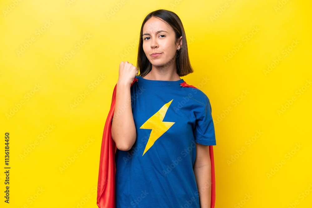 Young caucasian woman isolated on yellow background in superhero costume Young caucasian woman isolated on yellow background in superhero costume