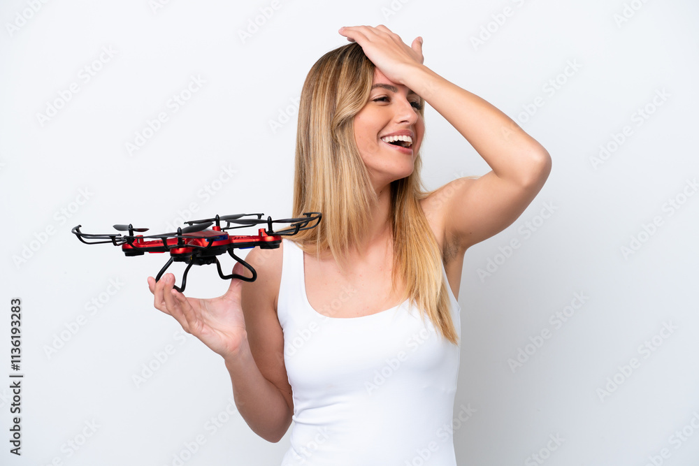 Young Uruguayan woman holding a drone isolated on white background has realized something and intending the solution Young Uruguayan woman holding a drone isolated on white background has realized something and intending the solution