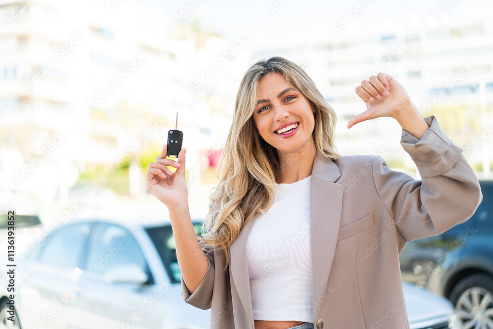 Pretty blonde Uruguayan woman holding car keys at outdoors proud and self-satisfied Pretty blonde Uruguayan woman holding car keys at outdoors proud and self-satisfied
