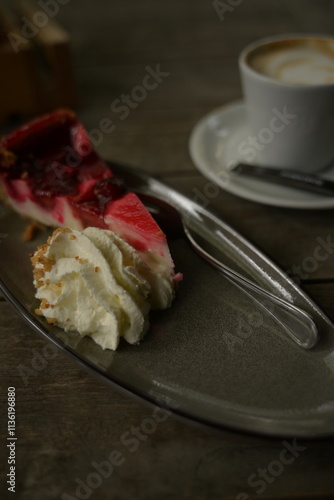 kuchenstück mit sahne und einem kaffee im hintergrund