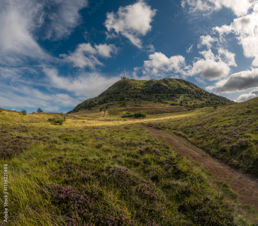 hiking trail Puy de Dôme tower paragliders blue sky green landscape hiking trail Puy de Dôme tower paragliders blue sky green landscape