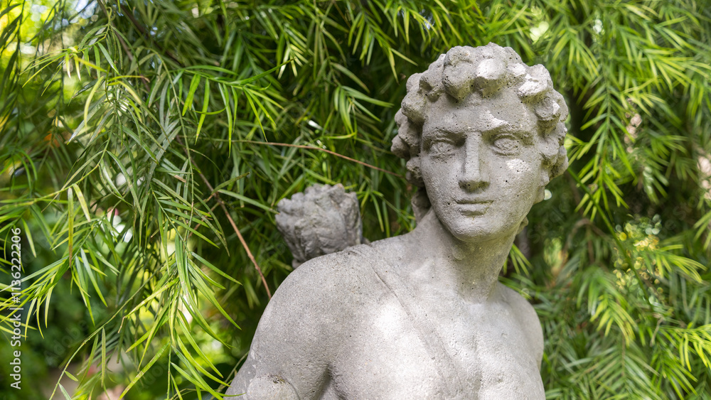 A statue of a person in a tropical garden setting A statue of a person in a tropical garden setting