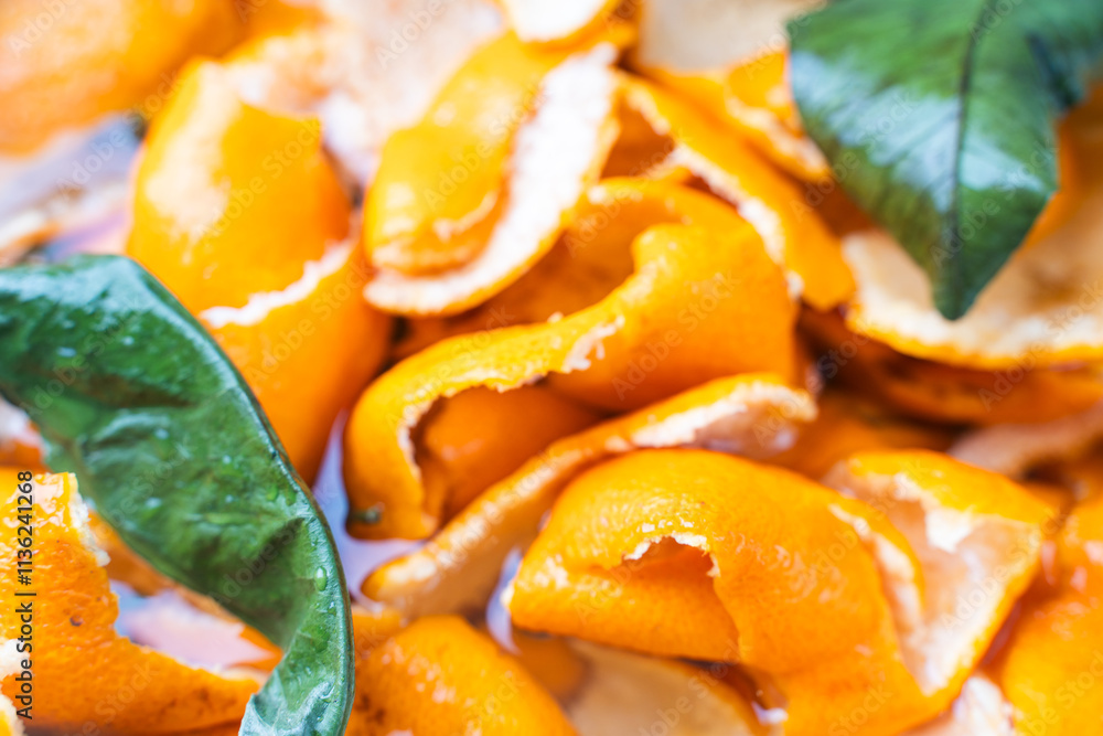 Tangerine zest or peels soaked in water for making candied fruit. Close-up. Background. Tangerine zest or peels soaked in water for making candied fruit. Close-up. Background.