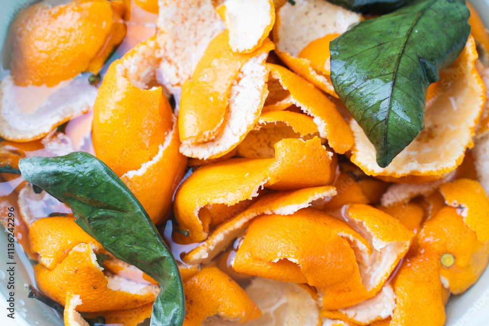 Tangerine zest or peels soaked in water for making candied fruit. Close-up. Background. Tangerine zest or peels soaked in water for making candied fruit. Close-up. Background.