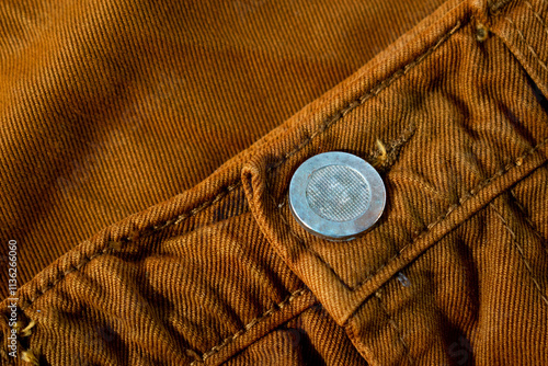 Metallic button on bright brown jeans, fabric texture mockup