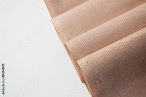 Multi folded light brown fabric background texture.