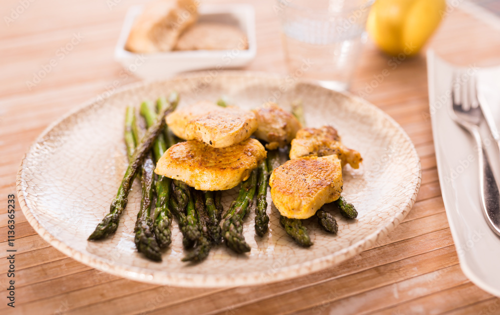 Fried chicken breast pieces with asparagus on white plate Fried chicken breast pieces with asparagus on white plate