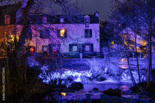  La Promenade Xavier Grall, décorée de lumières de Noël, offre une vue magique sur Pont-Aven sous un ciel hivernal, créant un cadre idyllique pour les visiteurs.