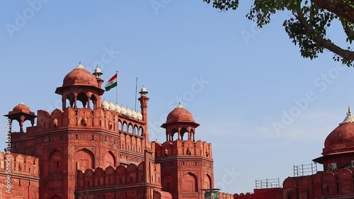 Beautiful scenery of the Red Fort with swaying indian flag against bright blue sky, Delhi, India. Real time motion video.