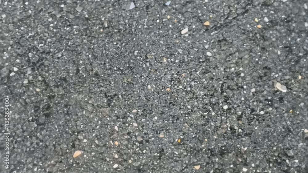 Camera zooms in to reveal a granite countertop texture featuring speckled grays and blacks with rugged, crystalline patterns, natural light highlights the texture's durability and natural beauty Camera zooms in to reveal a granite countertop texture featuring speckled grays and blacks with rugged, crystalline patterns, natural light highlights the texture's durability and natural beauty
