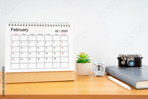 Desktop Calendar for February 2025 year and vintage camera with diary for Planner to plan timetable. photo