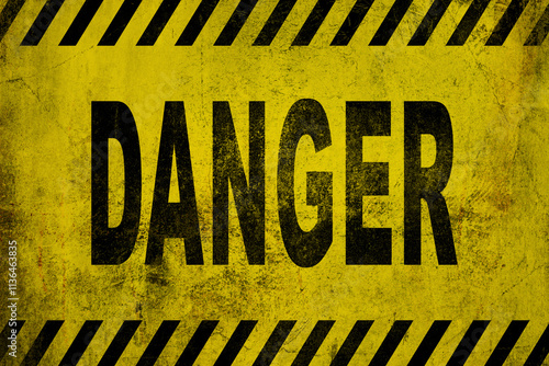 WARNING danger sign word text as stencil with yellow and black stripes painted over concrete wall cement texture wide banner background. Concept image for caution, dangerous area and hazard. photo