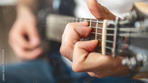 Guitar music. The performer plays. Practice chords. Male performer hands with fingers studying melody of song on electric string guitar fretboard indoors.