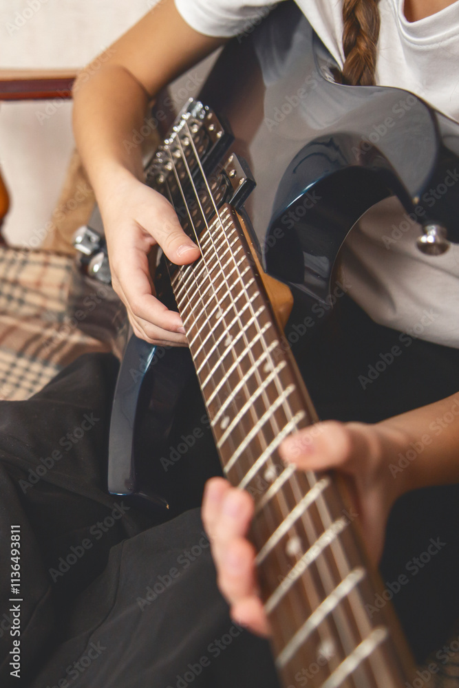 Fototapeta premium Close up. Girl playing electric guitar and practicing at home