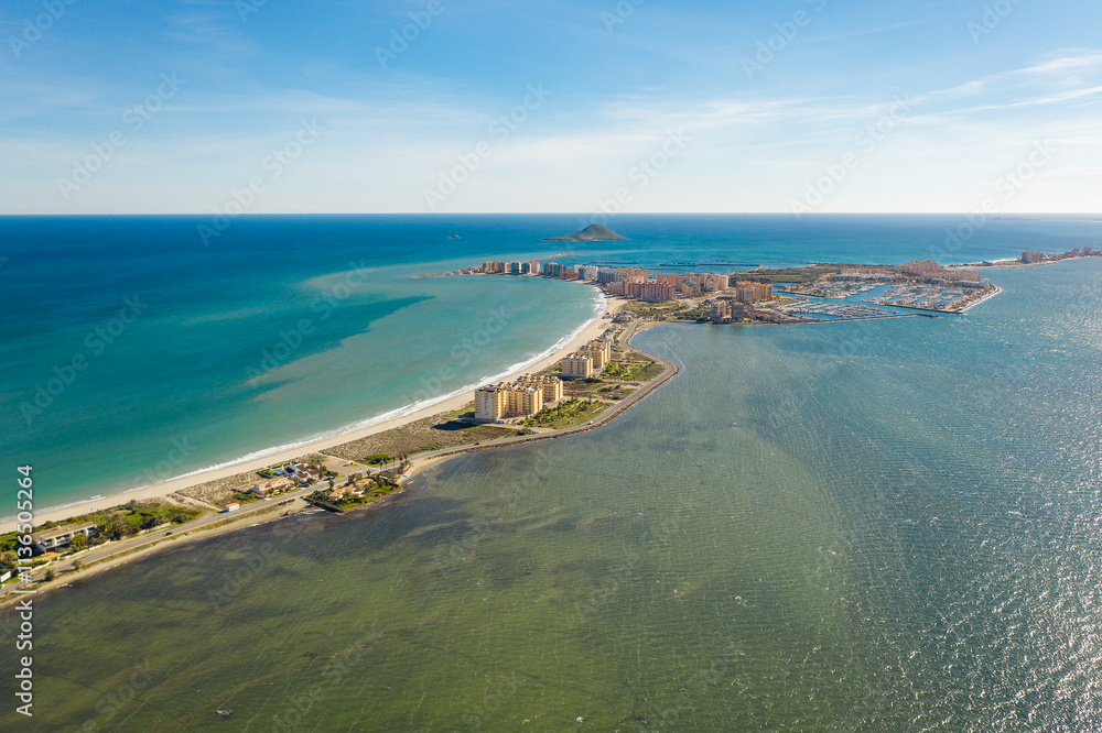 Fototapeta premium Aerial view of The Sandbar of the Minor Sea, is a seaside spit of Mar Menor in the Region of Murcia, Spain. The strip is 21 km long separating the Mediterranean Sea from the Mar Menor lagoon. Travel