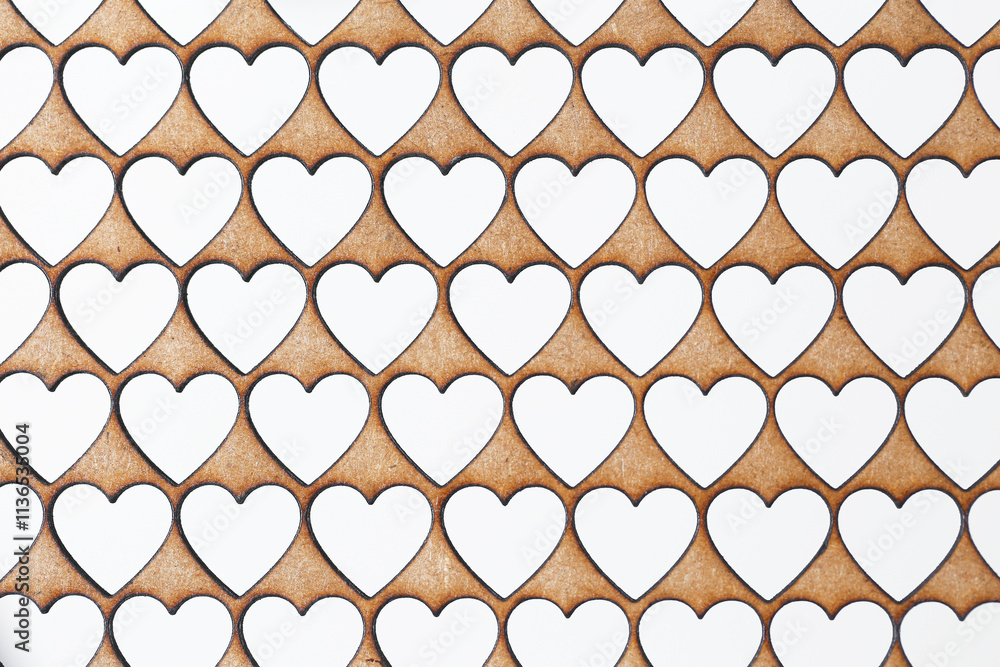 Fototapeta premium Laser cut heart pattern on HDF board. Repeating heart shapes for decorative backgrounds. Technical love inspired design. Creative and precise laser craftsmanship for romantic projects and wallpapers.