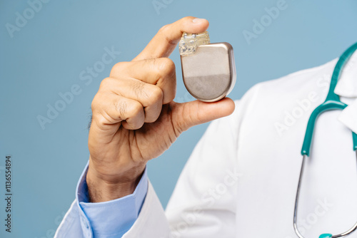 Portrait of professional doctor, cardiologist holding pacemaker selective focus on hands, closeup