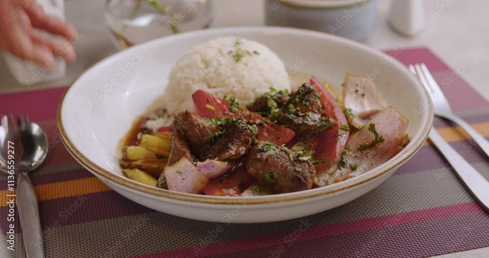 Closeup of Peruvian Sauteed Loin with rice being served on a restaurant's table. Closeup of Peruvian Sauteed Loin with rice being served on a restaurant's table.