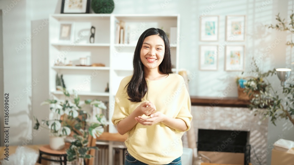 Young entrepreneur looking at camera while standing at home office. Happy female seller staring at camera with confidence while smiling with confidence. Small business or start up concept. Myrmidon. Young entrepreneur looking at camera while standing at home office. Happy female seller staring at camera with confidence while smiling with confidence. Small business or start up concept. Myrmidon.