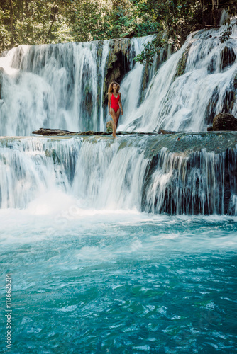 Woman in red swimwear on cascade waterfalls in Central Sulawesi photo