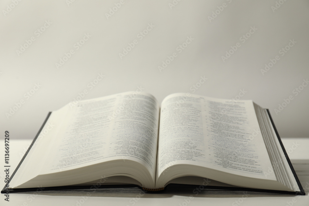 Open Holy Bible in English language on white table. Space for text Open Holy Bible in English language on white table. Space for text