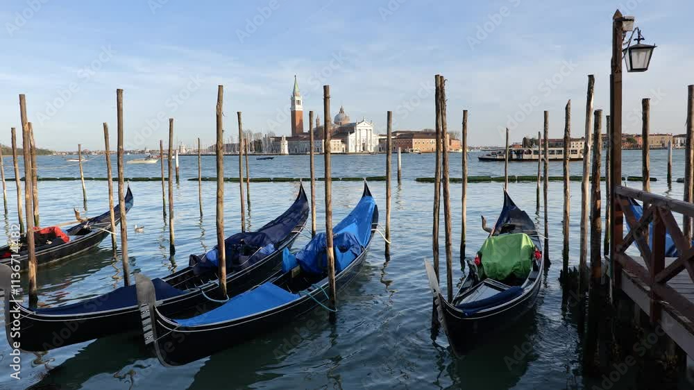 Venice Lagoon in Italy, Gondolas traditional Venetian boats at Riva degli Schiavoni waterfront and San Giorgio Maggiore island.