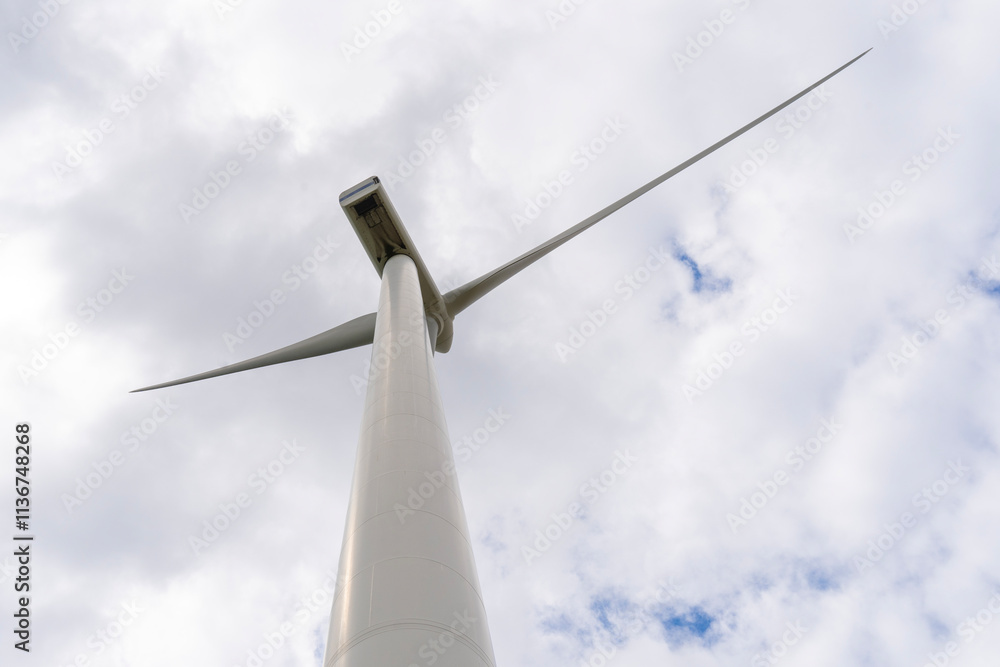 Wind turbine under cloudy blue sky Wind turbine under cloudy blue sky