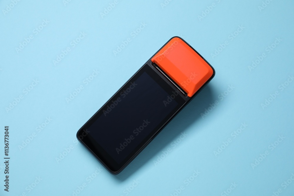 One payment terminal on light blue background, top view One payment terminal on light blue background, top view
