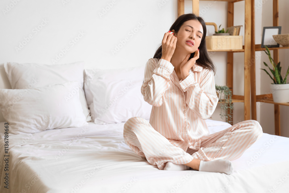 Young woman with otitis using ear drops in bedroom Young woman with otitis using ear drops in bedroom