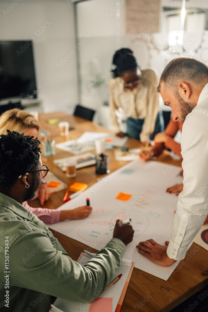 © Zamrznuti tonovi - Diverse business team drawing mind map during brainstorming session